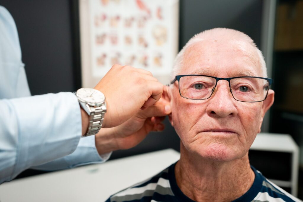 Audiologist examining a patient before a neurologist referral