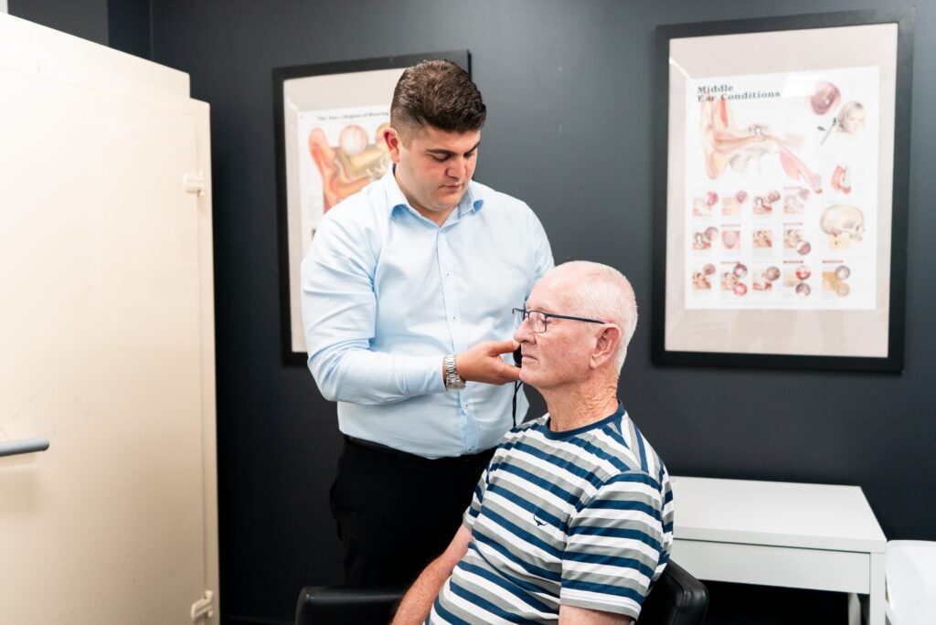 Audiologist assessing an older patient for cochlear implant candidacy